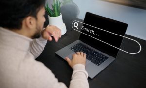 hands and laptop hologram with search engine